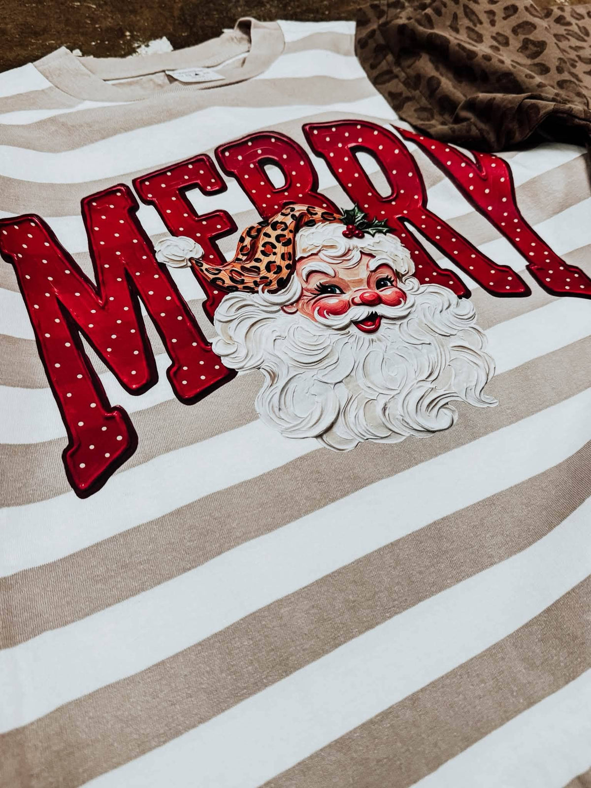 Merry Santa striped tan short sleeve graphic tee by Small Town Society Apparel Co. featuring festive holiday design.