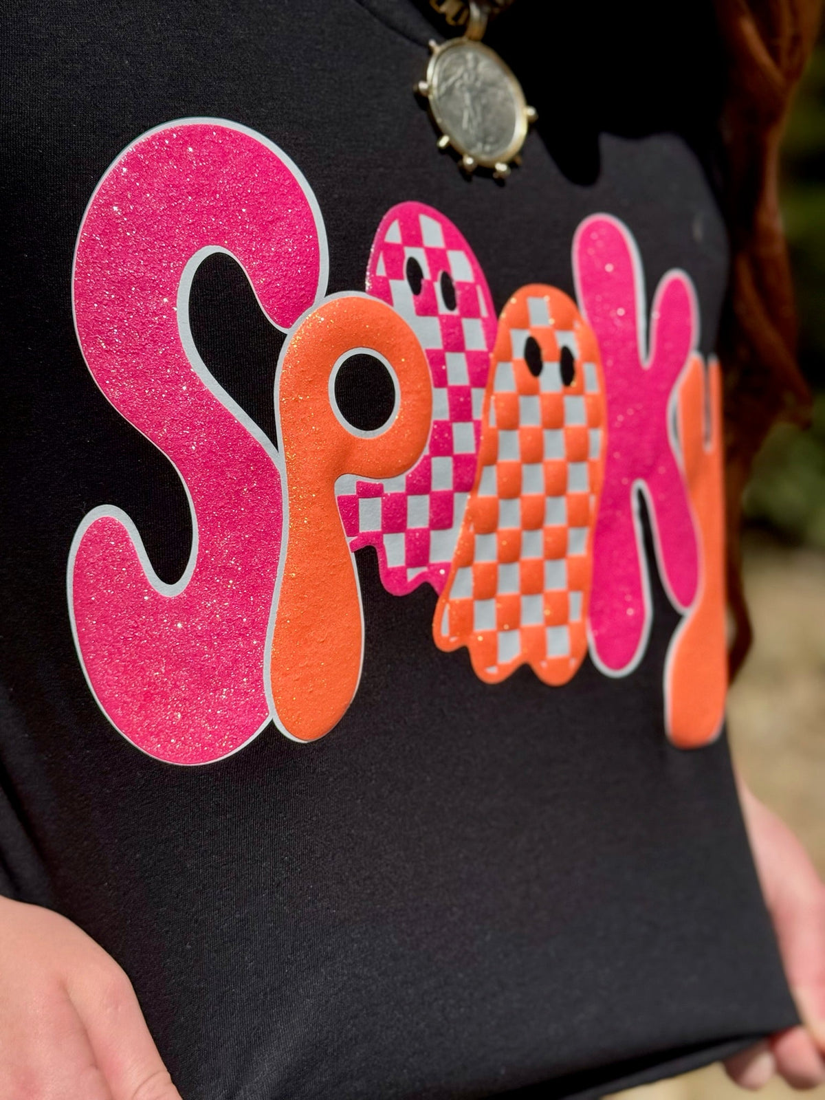 Sparkly black Spooky Tee in glitter puff lettering from Texas True Threads, featuring a spooky Halloween design on soft cotton fabric.