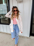 Pink Spring Lola Cardigan by BLAKELEY, lightweight knit with long sleeves and button closure, styled on a hanger.
