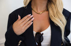 Gold pendant necklace by Chansuttpearls featuring a delicate gold chain and elegant pendant on a neutral background.