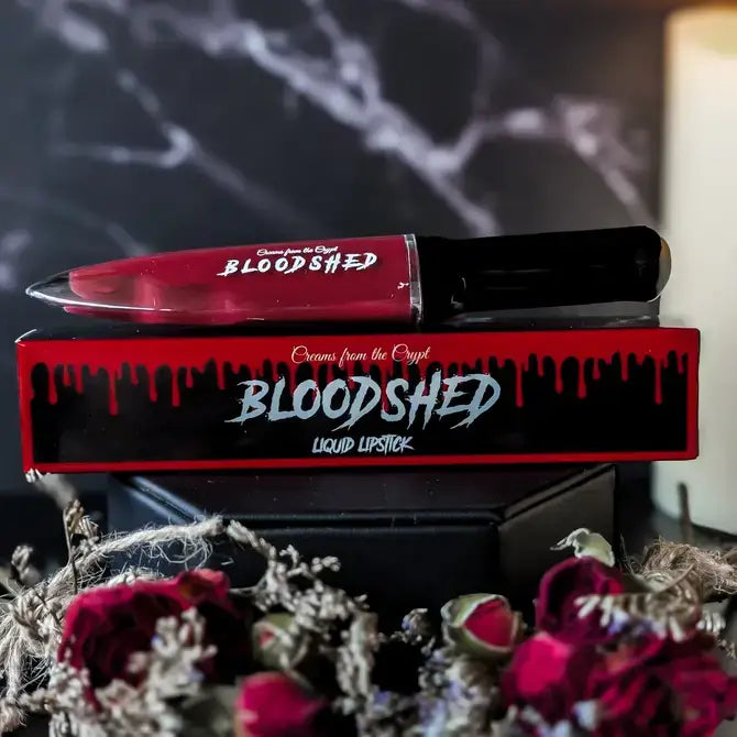 Crypt Cosmetics BLOODSHED knife-shaped slasher liquid lipstick in dark red, detailed with a blade design and glossy finish.