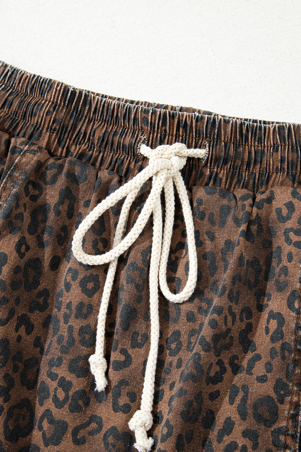 Brown leopard print denim skort with elastic waistband and drawstring, featuring cotton and elastane blend for comfortable fit.