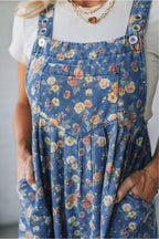 Blue vintage rose printed denim overall jumpsuit with pleated, loose fit, made of cotton, polyester, and viscose fabric.