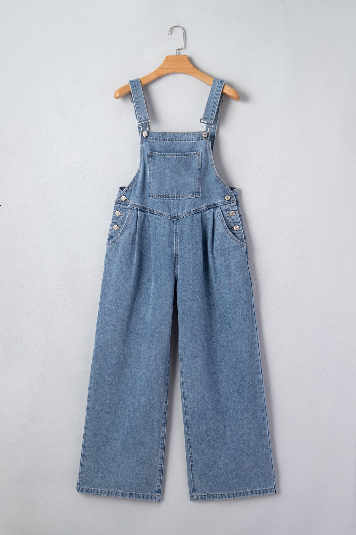 Dusk blue pleated wide-leg denim jumpsuit with retro pockets, featuring a relaxed fit and stylish design.