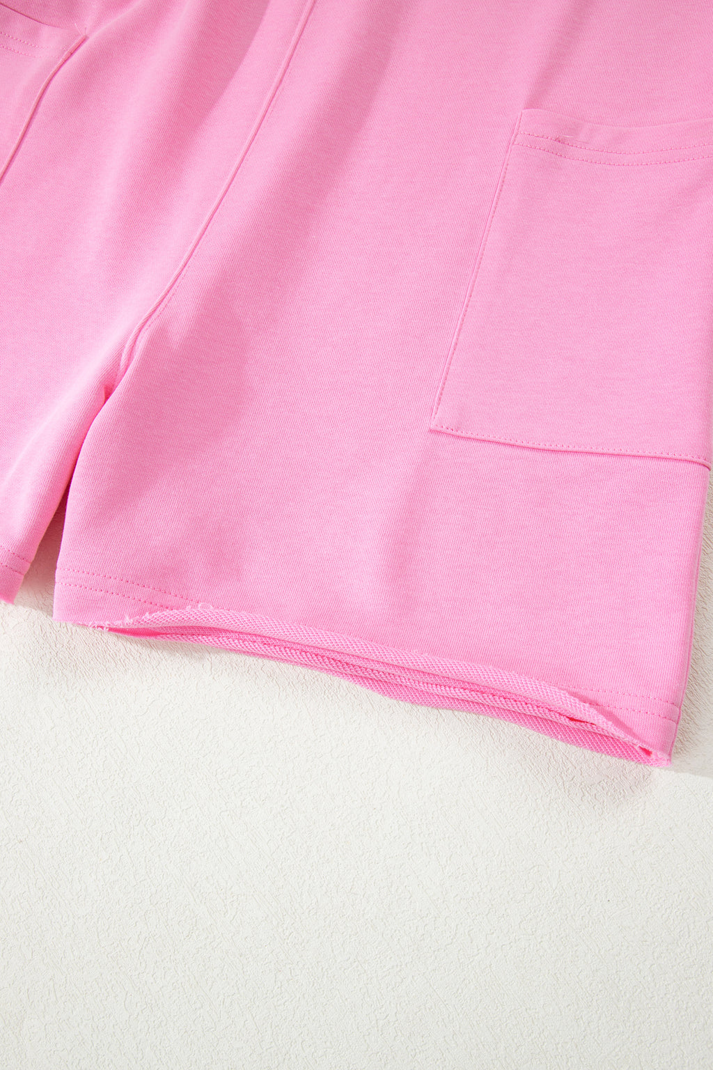 Pink solid color raw edge half sleeve romper with pockets, loose fit, made of cotton and polyester, from Dear-Lover Dropshipping.