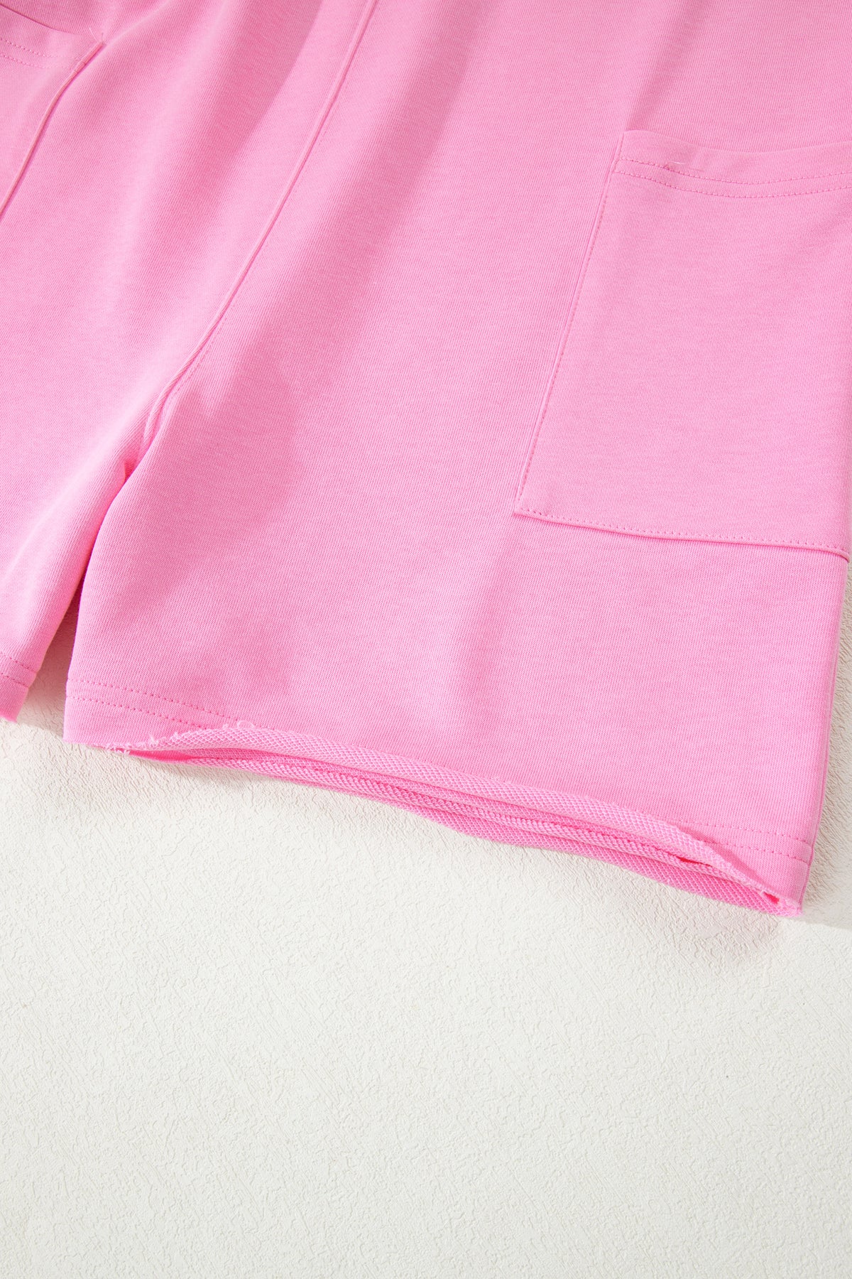 Pink solid color raw edge half sleeve romper with pockets, loose fit, made of cotton and polyester, from Dear-Lover Dropshipping.
