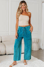 Medium grey high waist lace-up pants with raw hem, patched pockets, and lapis mineral wash finish, made of 100% cotton.