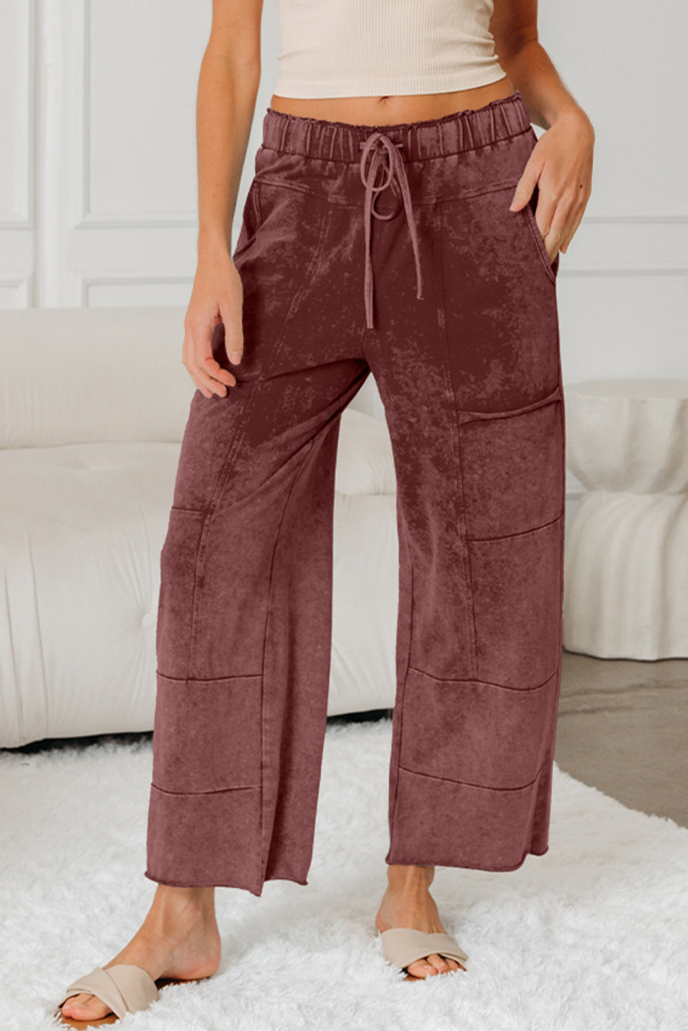 Medium grey lace-up high waist pants with raw hem, patched pockets, and lapis mineral wash, made of 100% cotton.