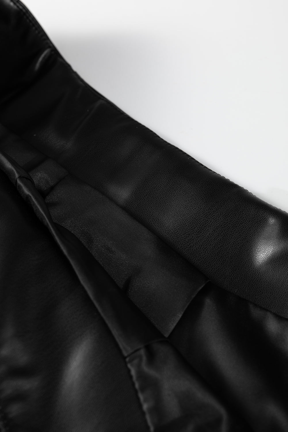 Black faux leather retro buckle detail pleated flared midi skirt by Dear-Lover, showcasing its structured design and stitch details.