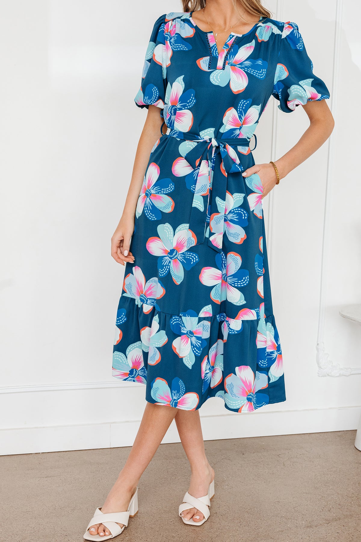 Blue floral print long dress with puff sleeves, ruffle hem, and belt, featuring polyester fabric and elegant design.