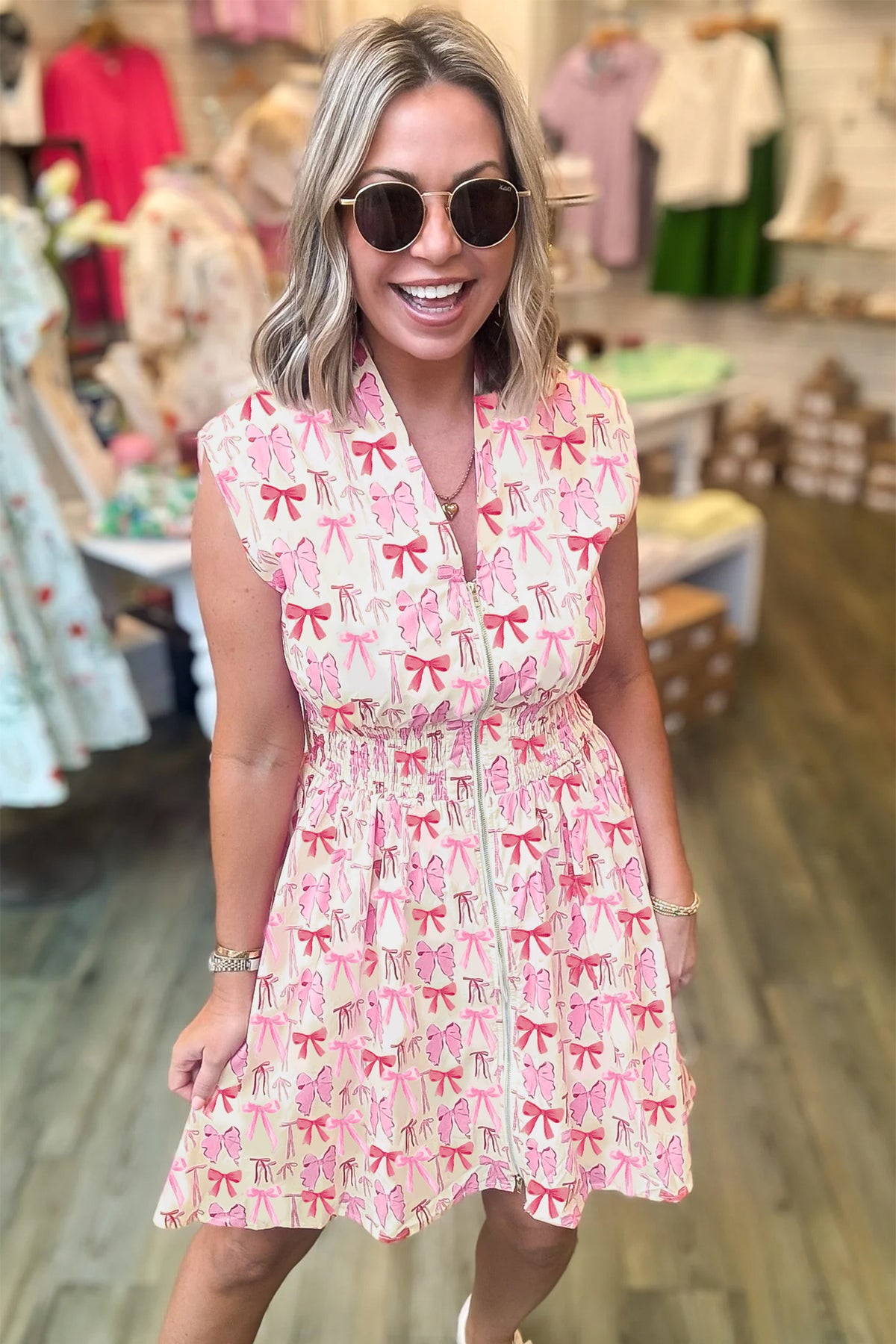Pink sleeveless mini dress with full zip, cinched waist, and bow detail by Dear-Lover, perfect for stylish summer wear.