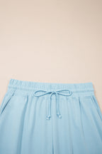 Plus size Mist Blue loungewear set with ribbed trim short sleeve top and drawstring loose pants, made of polyester and cotton blend.