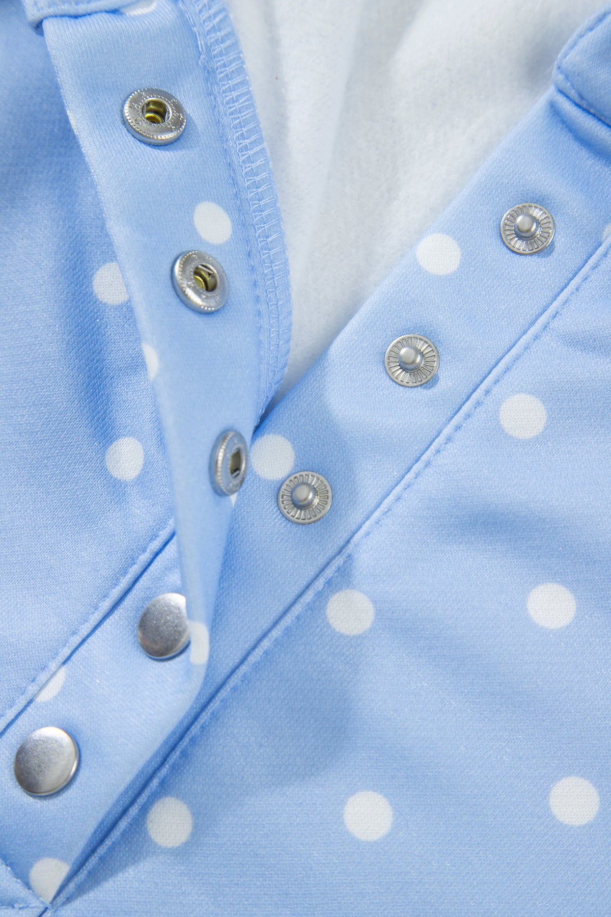 Sky blue polka dot plus size sweatshirt with V-neck, metal buttons, and long sleeves, made of soft polyester fabric.