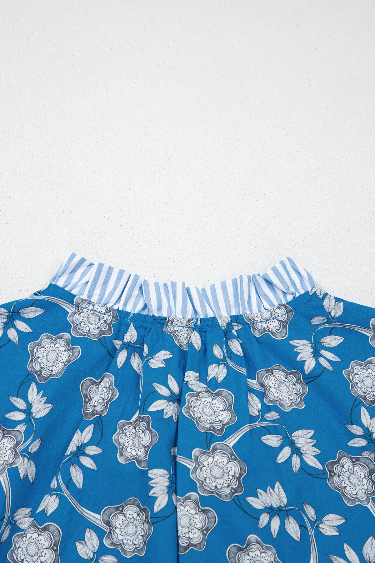 Blue floral print blouse by Dear-Lover with striped details, button tie neckline, short sleeves, made of 100% cotton.