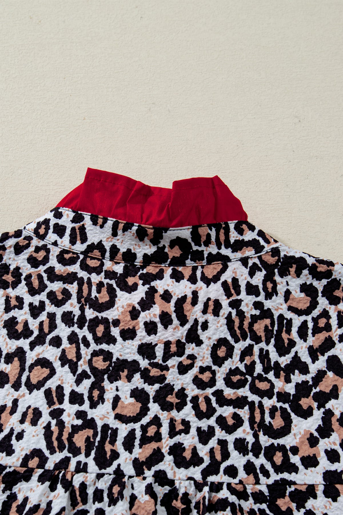 Khaki leopard print blouse with frilled V-neck trim by Dear-Lover, featuring contrast details and lightweight polyester fabric.