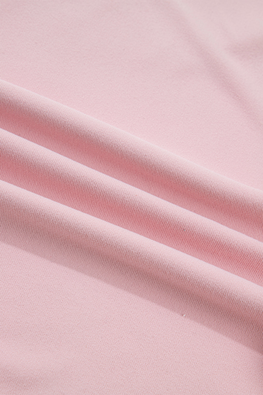 Light pink solid color long sleeve tee with textured bow patchwork, made by Dear-Lover, displayed on a flat surface.