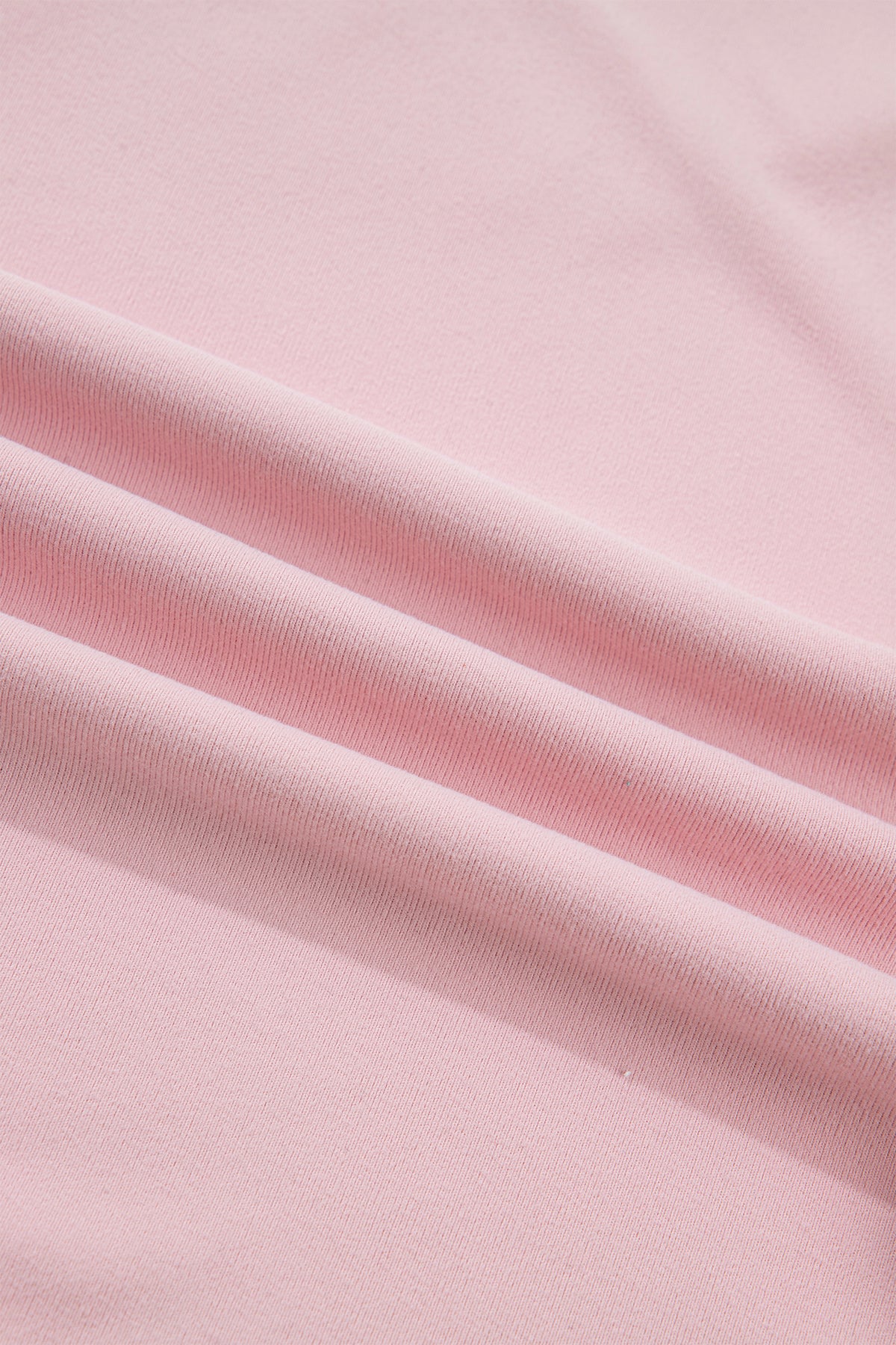 Light pink solid color long sleeve tee with textured bow patchwork, made by Dear-Lover, displayed on a flat surface.