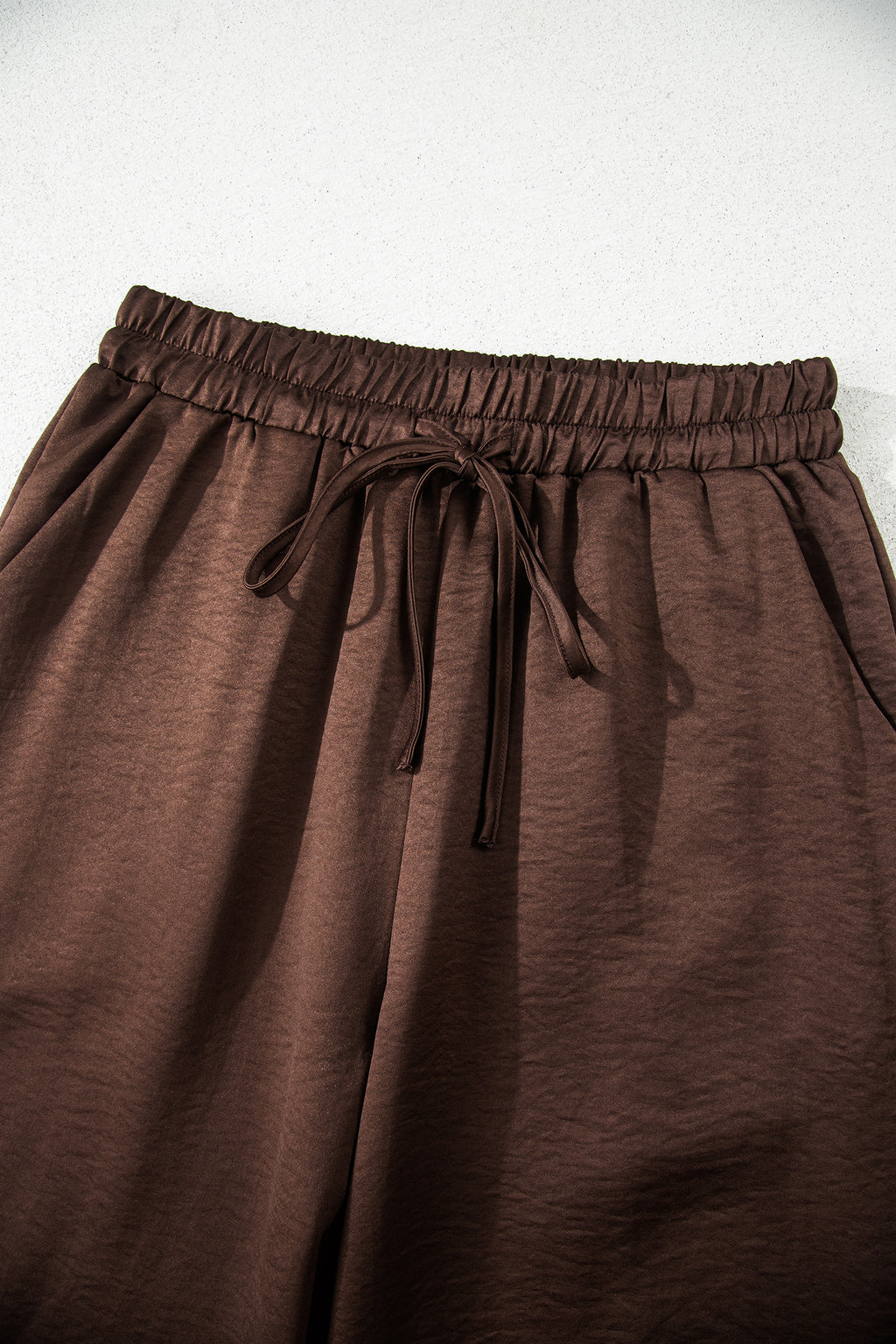 Dark brown braided V-neck long sleeve top with loose fit and matching high waist drawstring pants, part of a two-piece set.