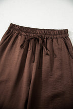 Dark brown braided V-neck long sleeve top with loose fit and matching high waist drawstring pants, part of a two-piece set.