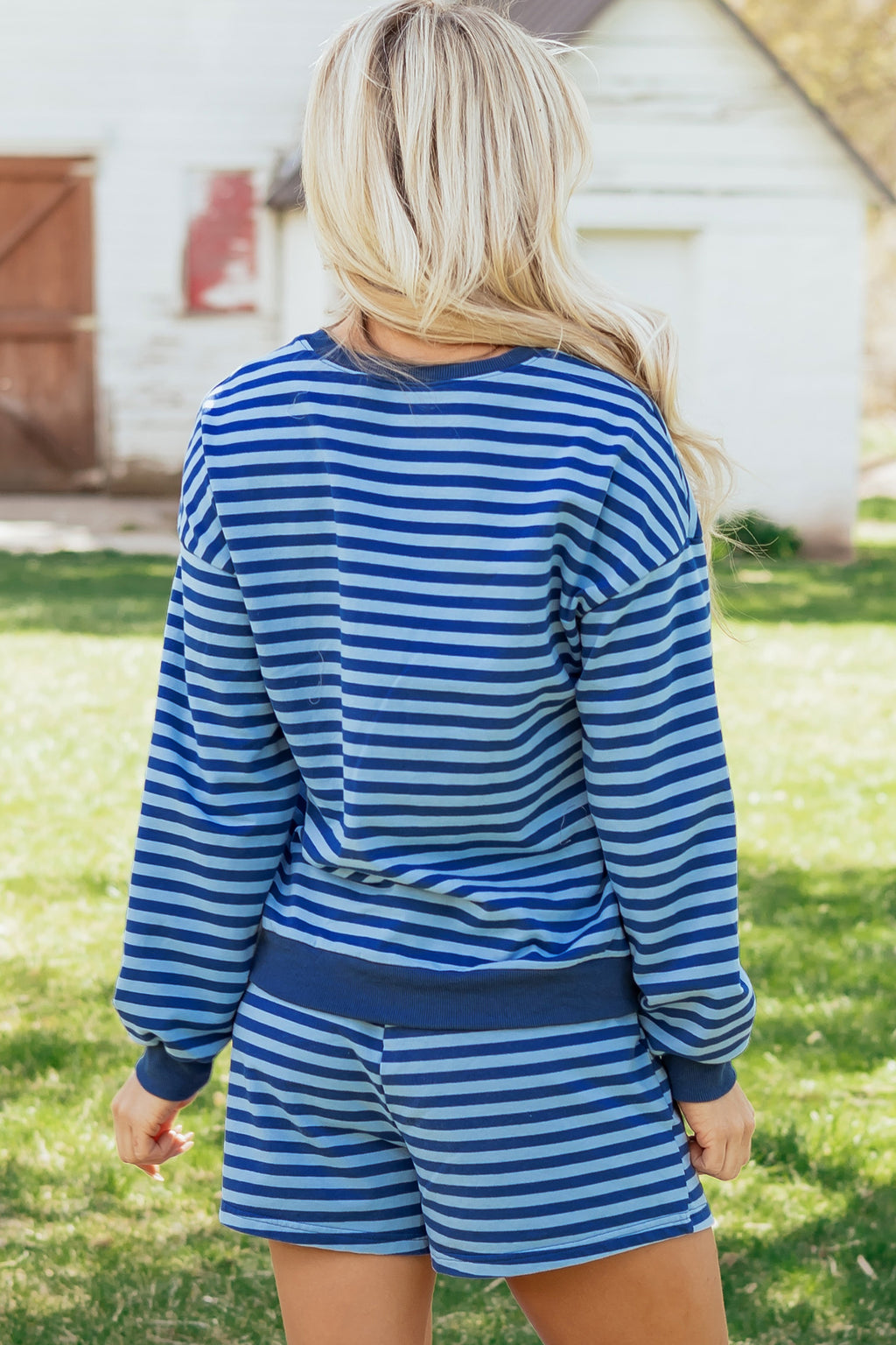 Blue stripe casual two-piece set with long sleeve drop shoulder pullover and elastic waist shorts, made of cotton and elastane.