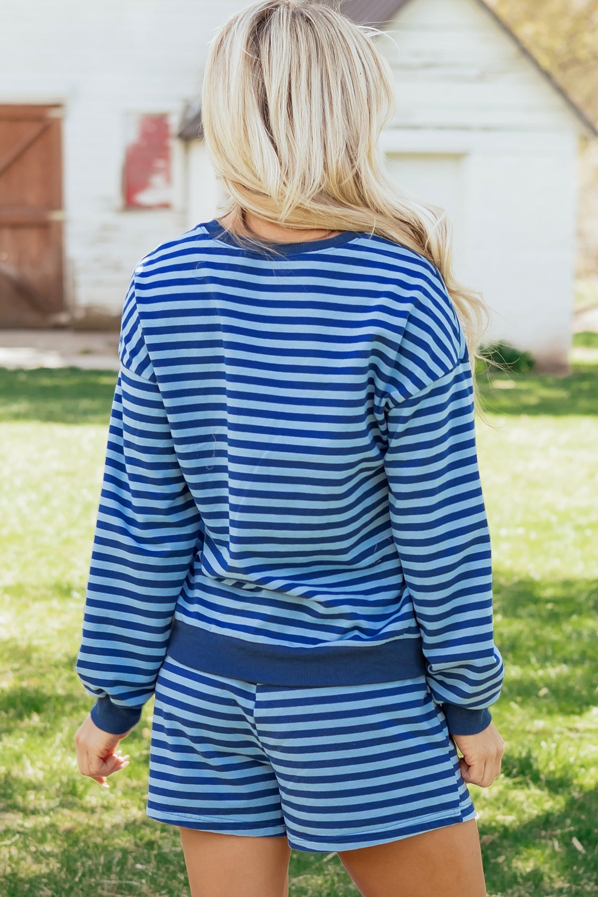 Blue stripe casual two-piece set with long sleeve drop shoulder pullover and elastic waist shorts, made of cotton and elastane.