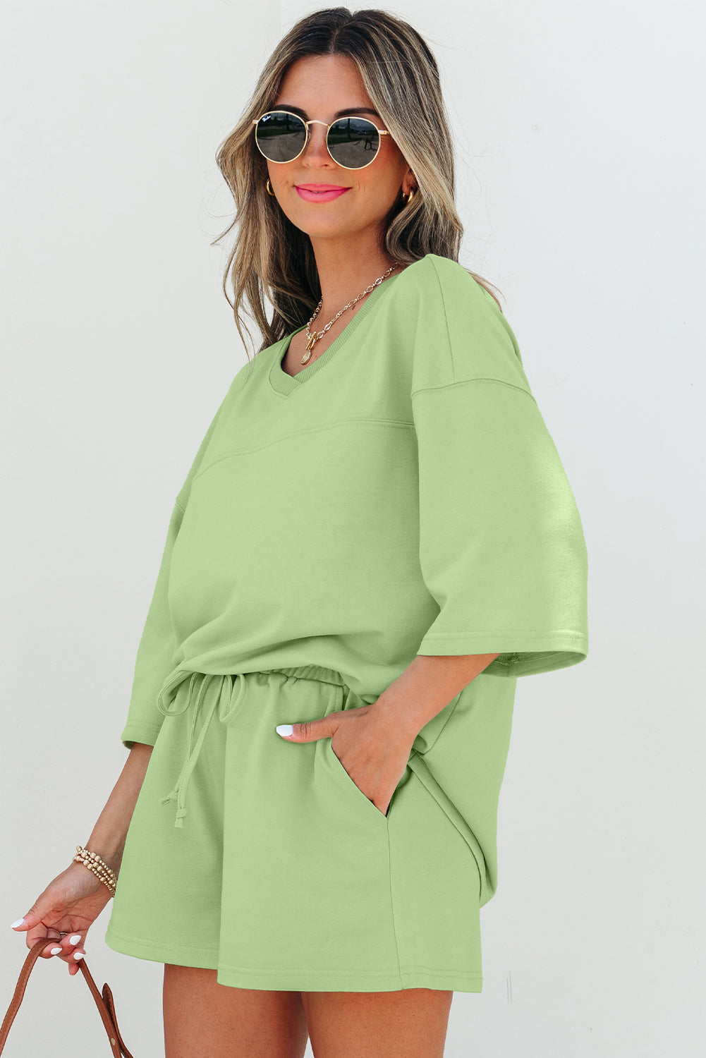 Meadow Mist Green two-piece set with loose V-neck half-sleeve tee and matching shorts, made of polyester, cotton, and elastane.
