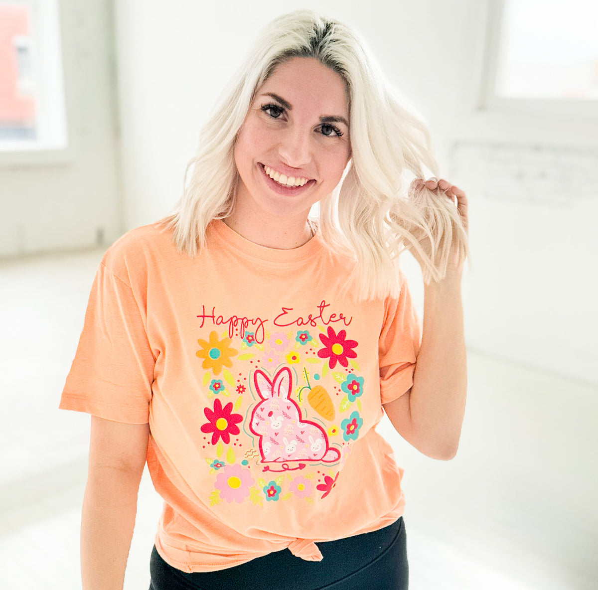 Women’s apricot Happy Easter Bunny graphic T-shirt by Envy Stylz Wholesale, featuring a festive bunny design.