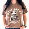 Women’s Stay Salty Cowgirl graphic T-shirt by Envy Stylz Wholesale, featuring a comfortable, stylish cowgirl design in espresso color.