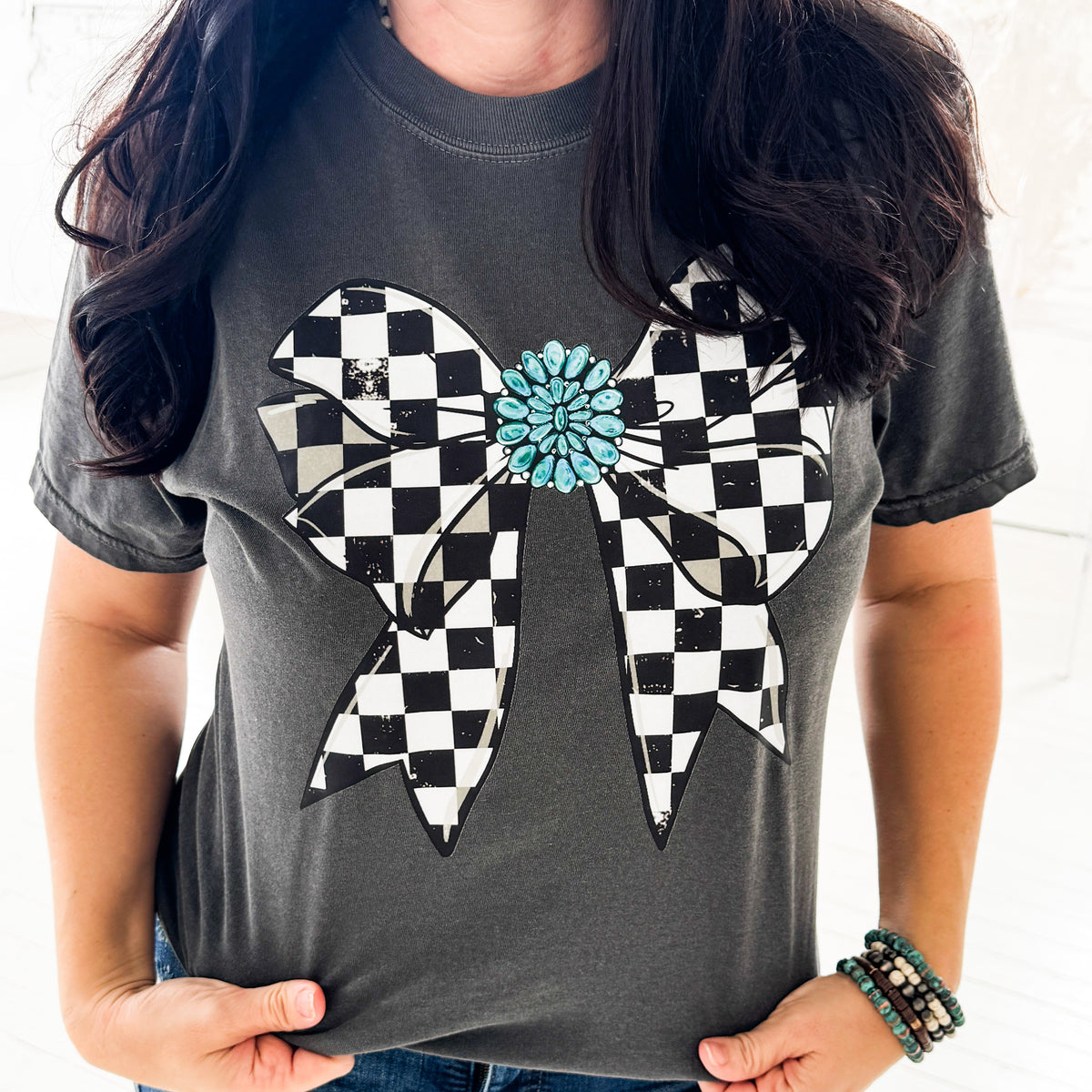 Women’s checkered bow graphic T-shirt by Envy Stylz Wholesale featuring turquoise gem design, casual comfortable apparel.