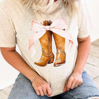 Women’s pink bow graphic T-shirt with western boots, casual Oatmeal shirt by Envy Stylz Wholesale for stylish everyday wear.