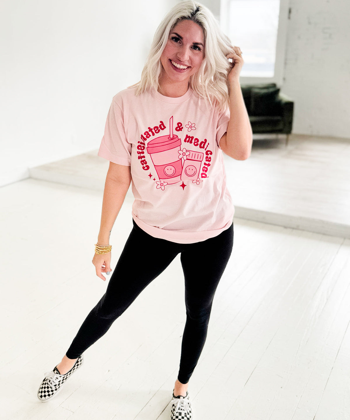 Pink Caffeinated & Medicated graphic T-shirt for women by Envy Stylz Wholesale, featuring bold caffeine and medication-themed print.