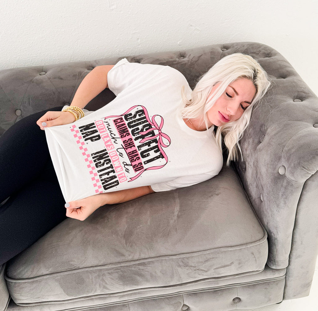 White women's graphic T-shirt by Envy Stylz Wholesale featuring the bold text "Suspect Claims She Has So Much To Do."