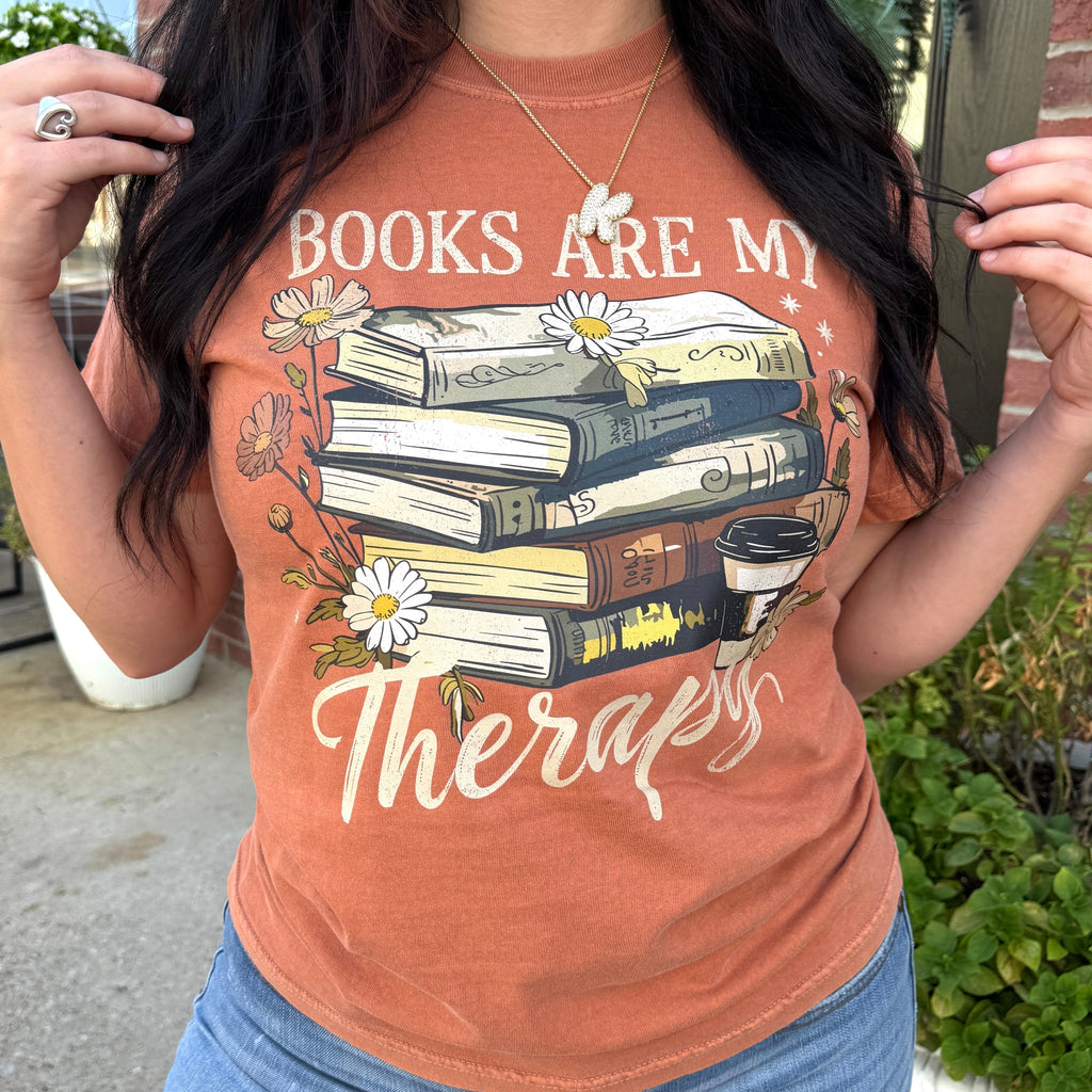 Women’s graphic T-shirt from FestiviTees featuring the phrase "Books Are My Therapy" in black print on a casual tee.