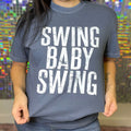 FestiviTees women's graphic t-shirt featuring a playful swing and baby swing design on denim-colored fabric.