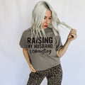 Women’s graphic T-shirt by FestiviTees featuring humorous "Raising My Husband Is Exhausting" design in comfort colors granite.