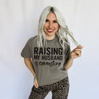 Women’s graphic T-shirt by FestiviTees with “Raising My Husband Is Exhausting” print in comfort colors granite.