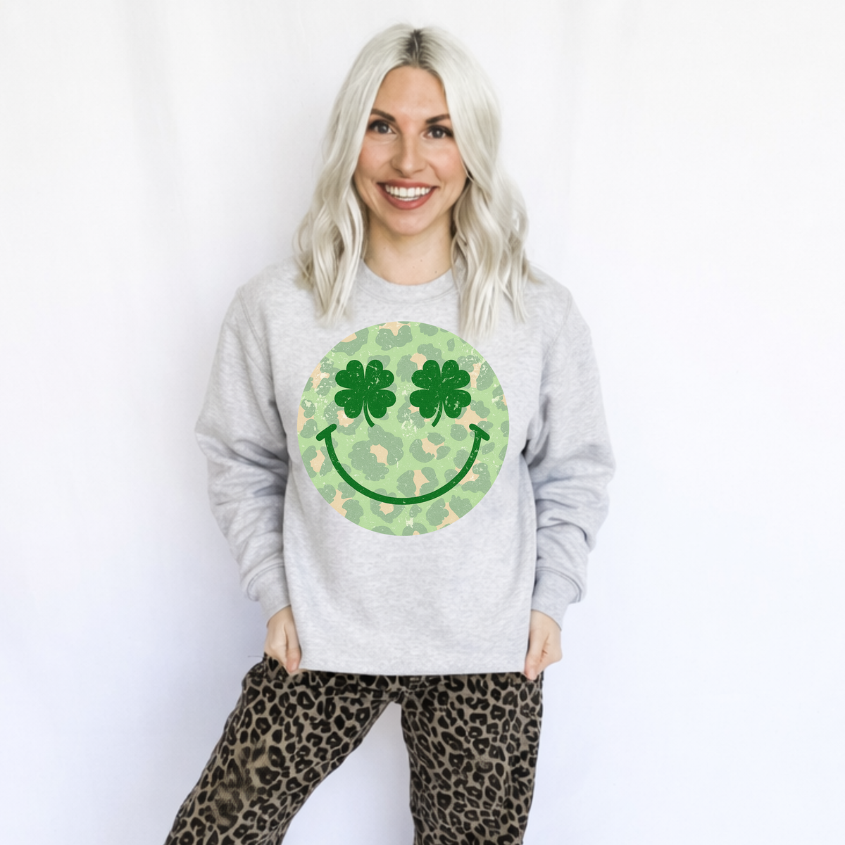Women’s Happy Leopard Shamrocks Sweatshirt by FestiviTees, ash-colored Gildan sweatshirt with festive shamrock and leopard print design.