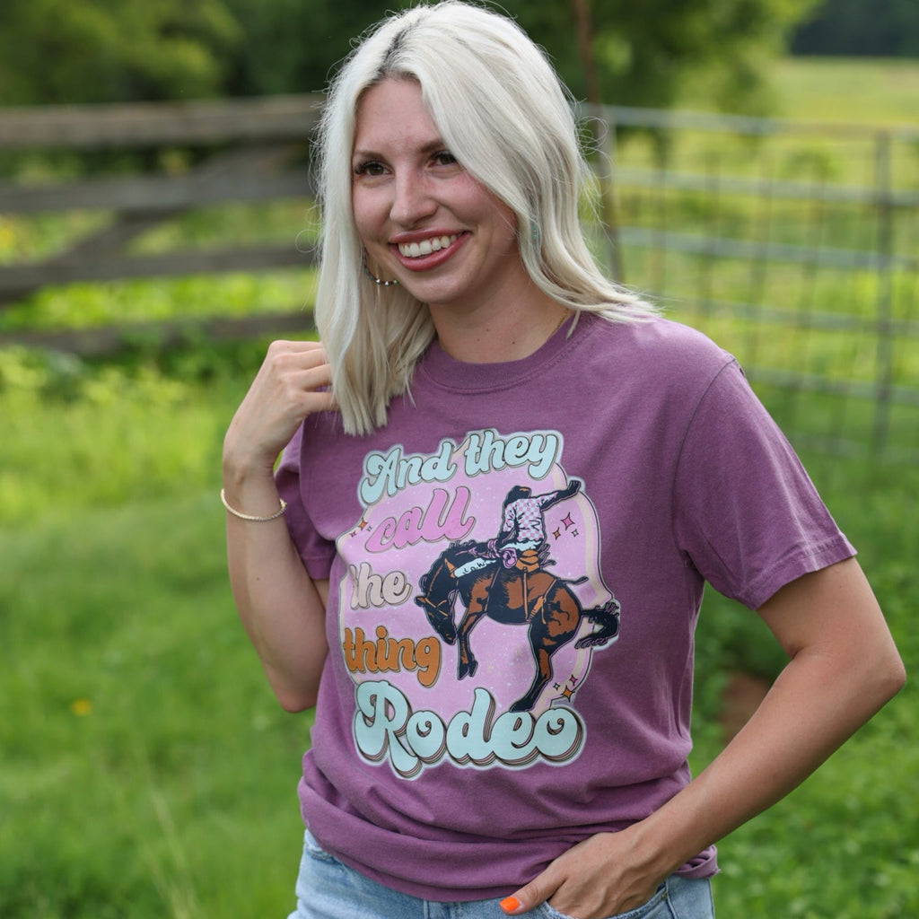 Women’s Call The Thing Rodeo graphic T-shirt by FestiviTees, featuring a colorful rodeo-themed design on a berry-colored shirt.