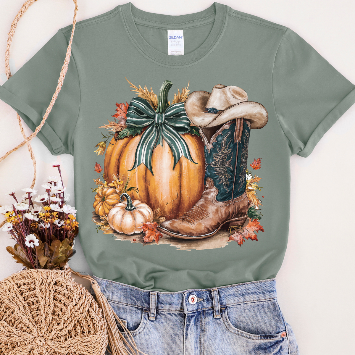 Women’s sage green T-shirt with pumpkin and cowboy boot graphic, casual FestiviTees apparel, perfect for fall.