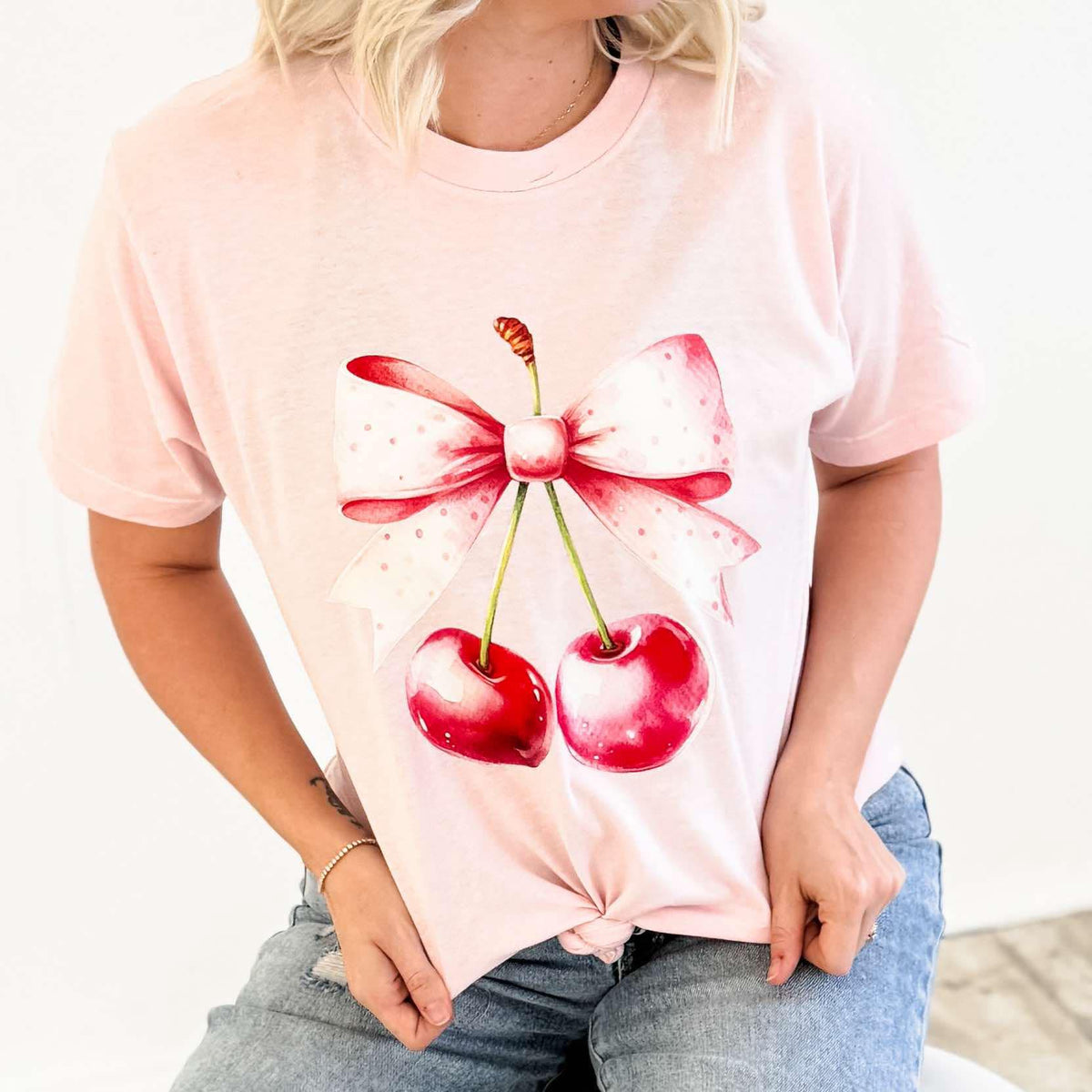 Pink watercolor cherries bow graphic T-shirt for women by FestiviTees, casual apparel with colorful cherry design.