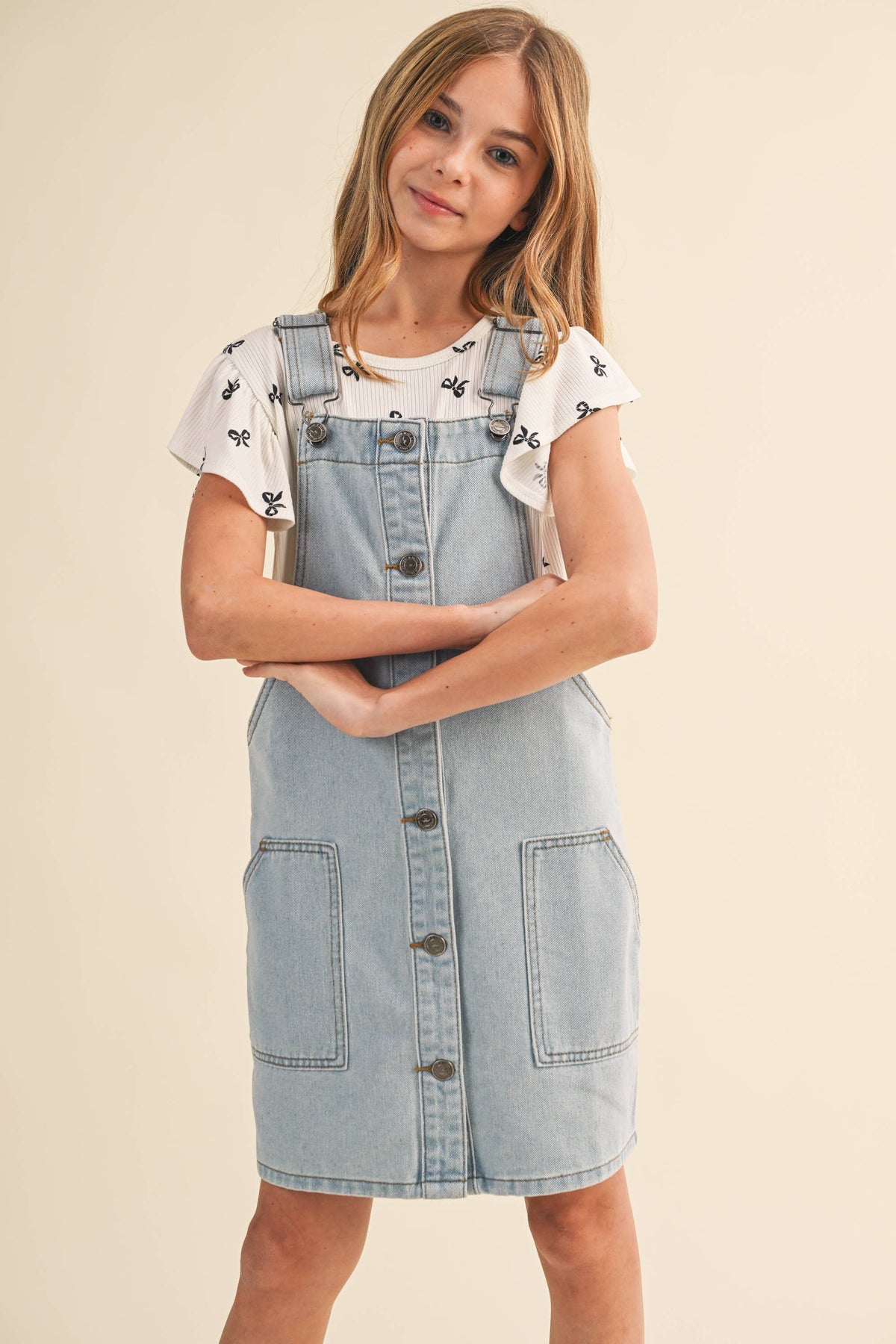 Tween girls' denim overall dress by Heart and Arrow, featuring classic blue denim with adjustable straps and front pockets.