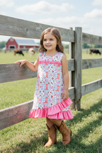 Kids Charm Online Western boot printed dress with fuchsia ruffle hem, featuring colorful western-themed print and vibrant ruffle detail.
