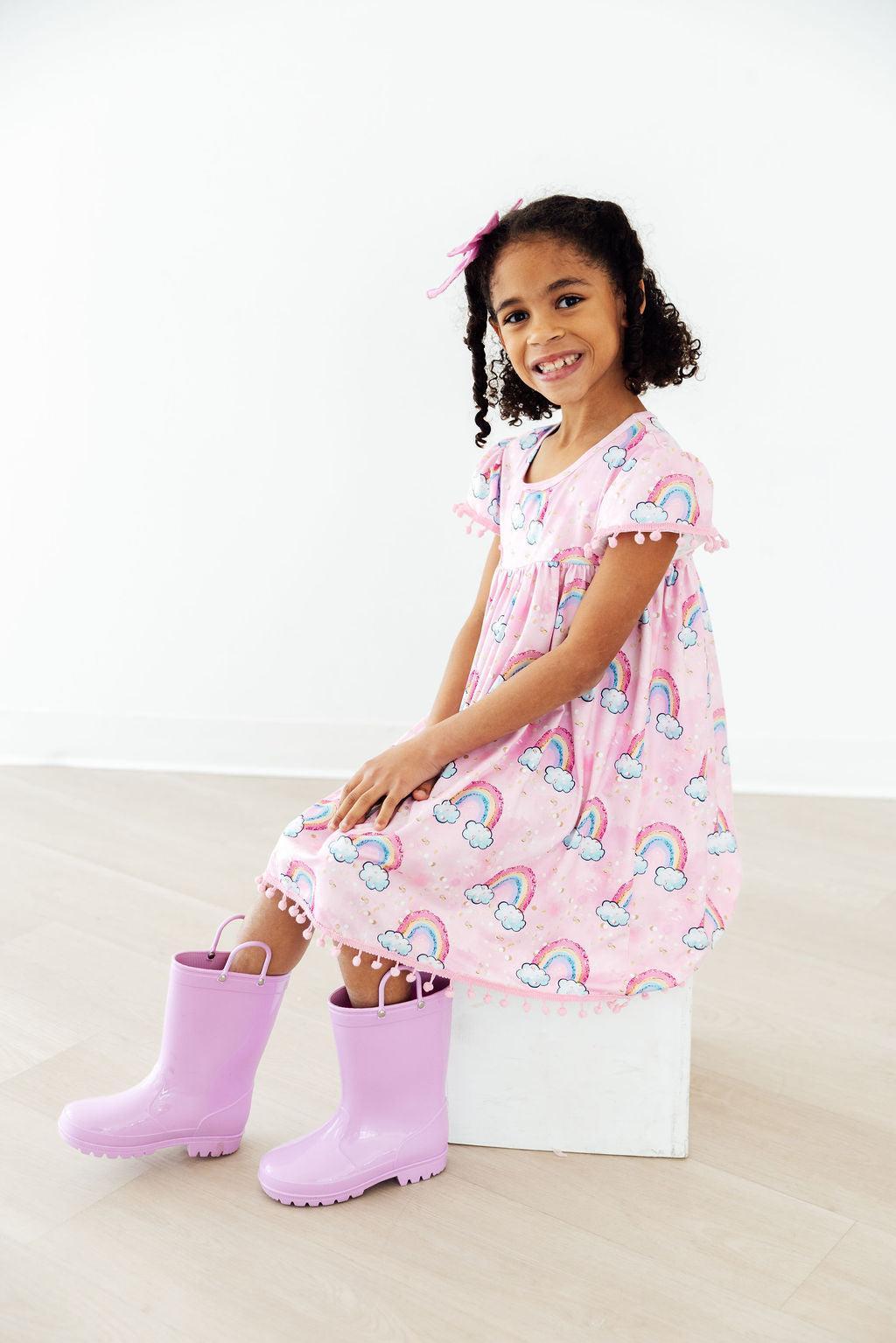 Mila & Rose® Sparkling Rainbows Pom Pom Dress for 12-24 months featuring colorful pom poms and a festive, playful design.