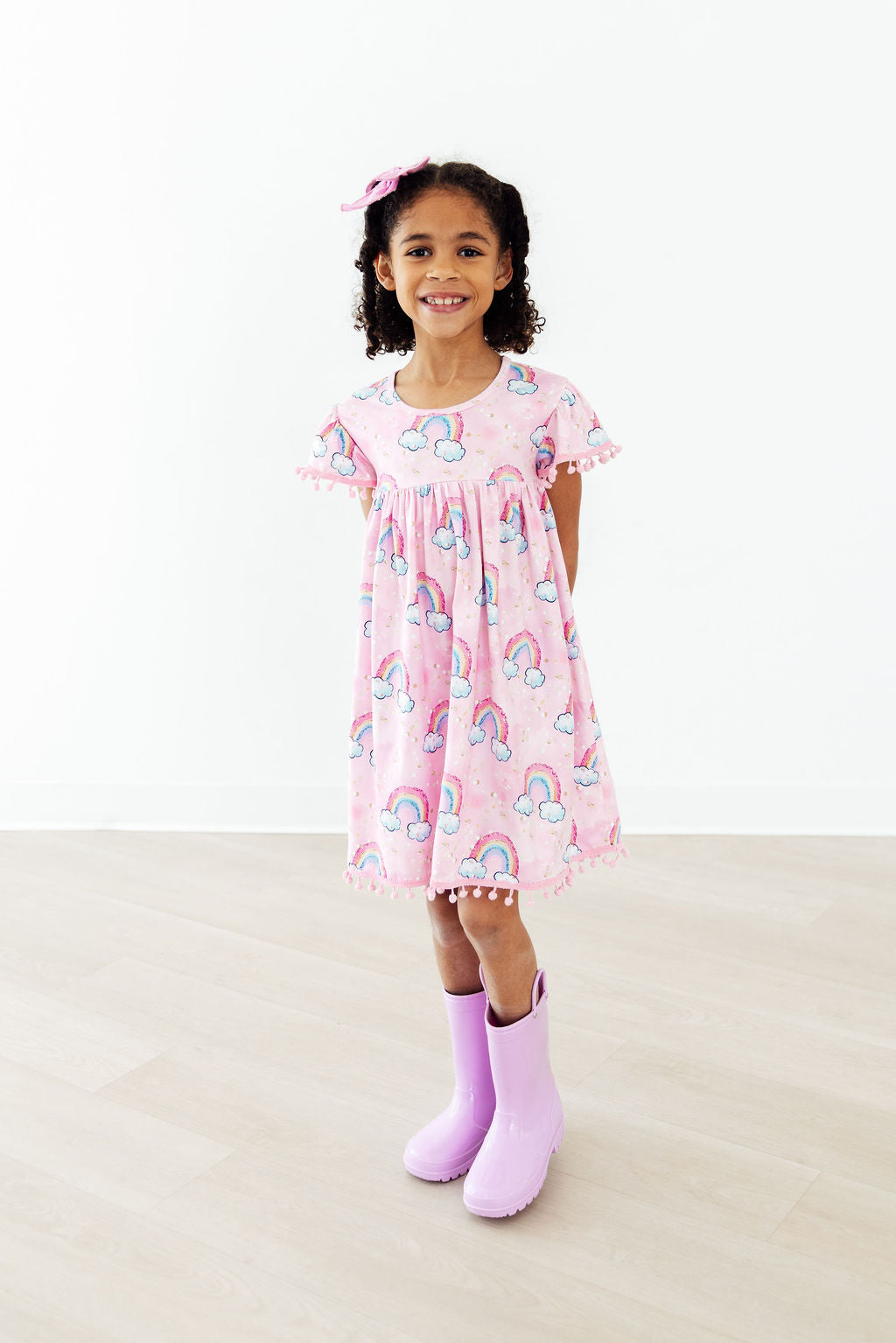 Mila & Rose® sparkling rainbows pom pom dress for toddlers, featuring colorful pom poms and a cheerful, festive design.