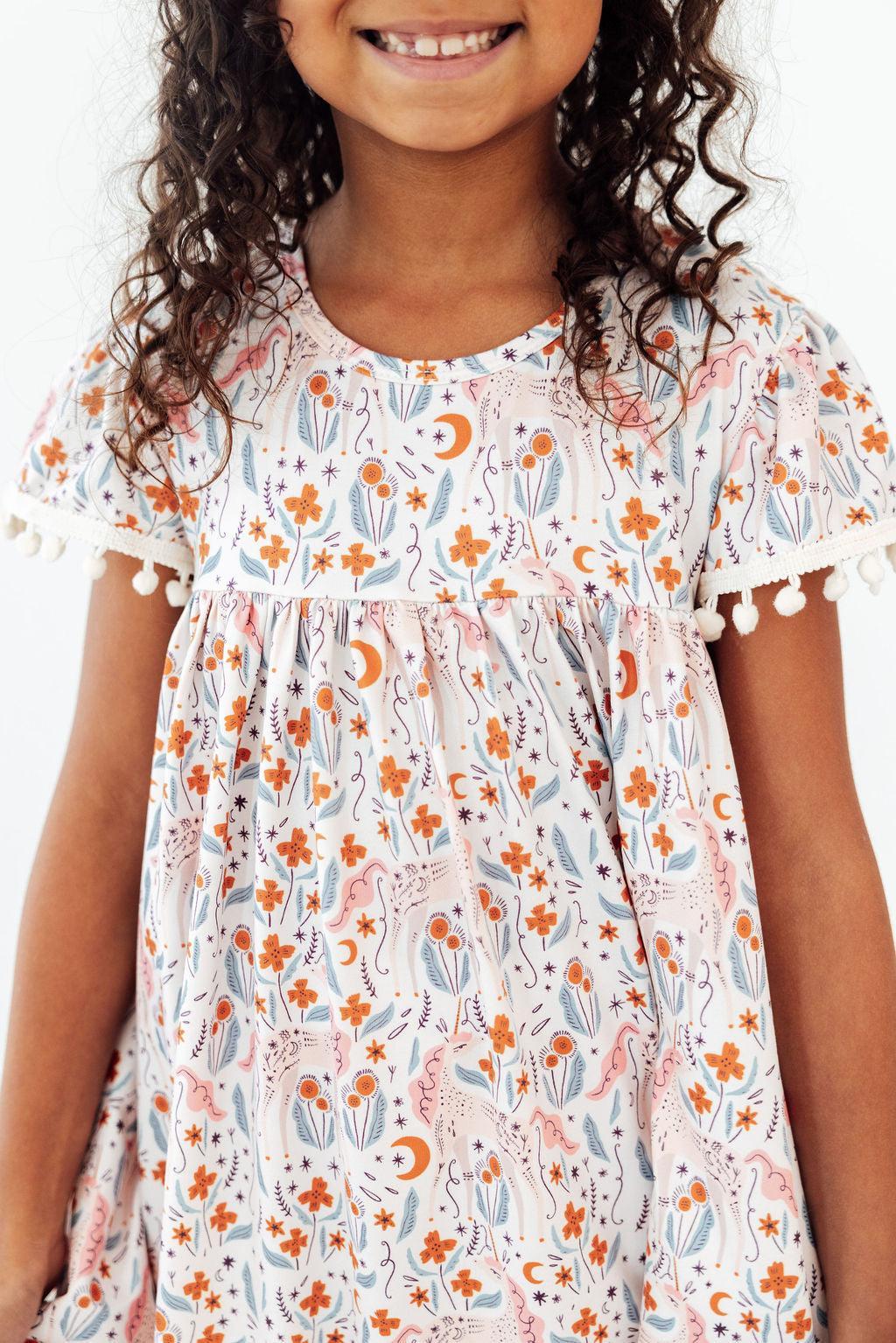 Mila & Rose unicorn-themed Pom Pom Dress for toddlers, featuring colorful pom pom details and a playful, festive design.