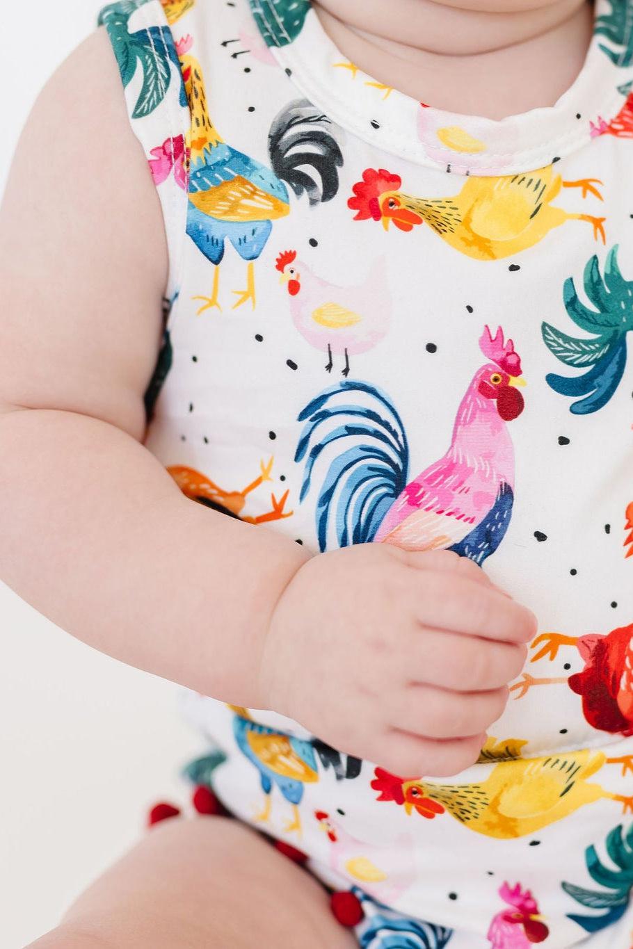 Cute Mila & Rose rooster pom pom romper for infants, featuring colorful pom poms and soft fabric, suitable for babies aged 0-6 months.