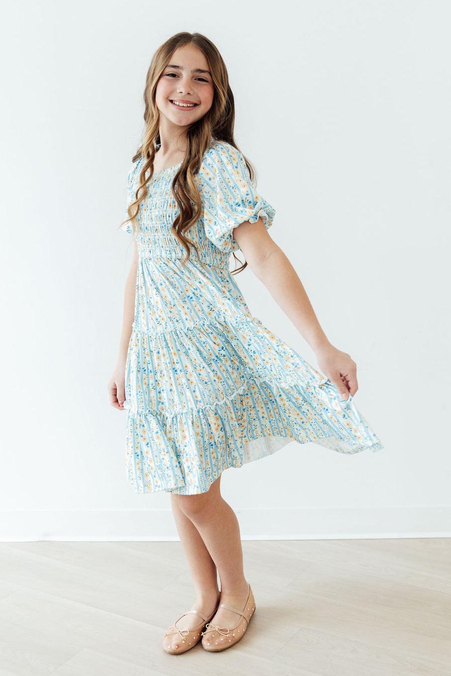 2T Mila & Rose Buttercup Blooms smocked ruffle dress with floral pattern, featuring ruffled sleeves and a smocked bodice.