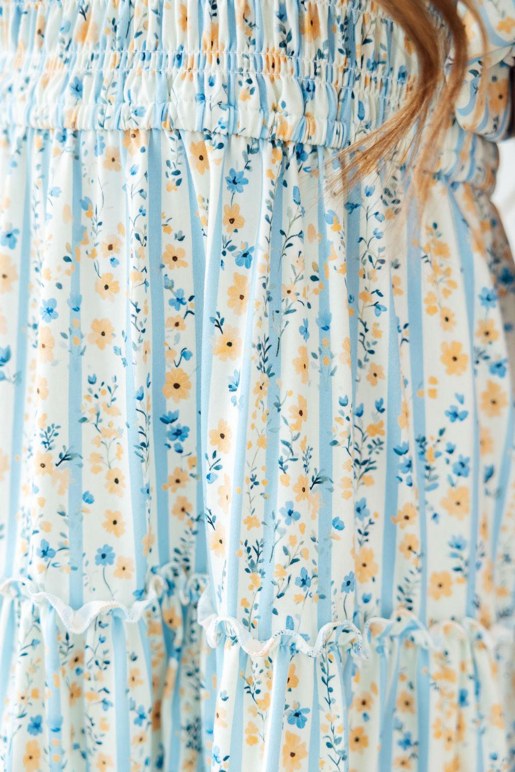 2T Mila & Rose Buttercup Blooms smocked ruffle dress with floral pattern, featuring ruffle details and smocked bodice.