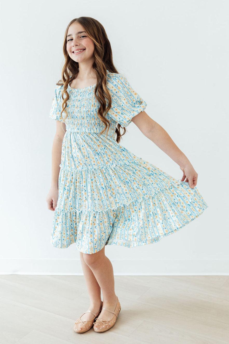 2T Mila & Rose Buttercup Blooms smocked ruffle dress with floral pattern, featuring ruffled sleeves and a smocked bodice.