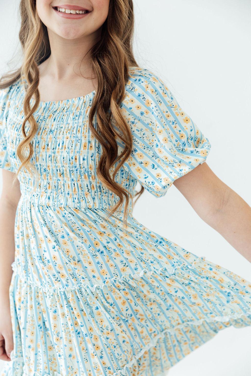 Mila & Rose Buttercup Blooms smocked ruffle dress for toddlers, featuring a floral pattern and delicate ruffle details.